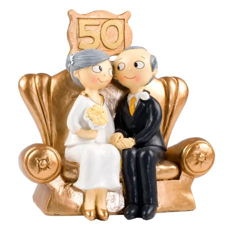 Simpática pareja sentada en un trono dorado, figura para celebrar las bodas de oro